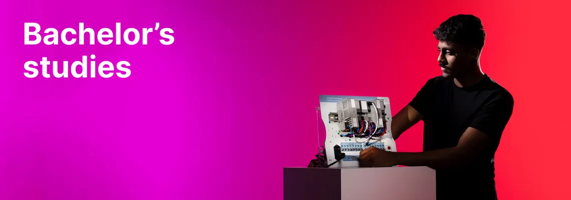 Choose bachelor's studies at KTU. A young international student working with an electrical or engineering control panel against a bright pink and red background.